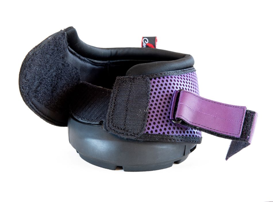 this cavallo trek hoof boot is facing forward with one velcro strap open and is a purple boot with a honeycomb mesh pattern